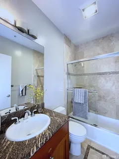 a bathroom with a granite countertop sink toilet and shower