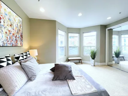 a large bedroom with a bed and large windows