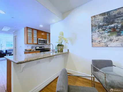 a kitchen with stainless steel appliances granite countertop a sink and a granite counter tops with white walls