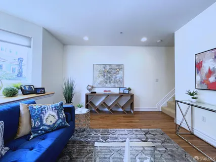 a living room with furniture and wooden floor
