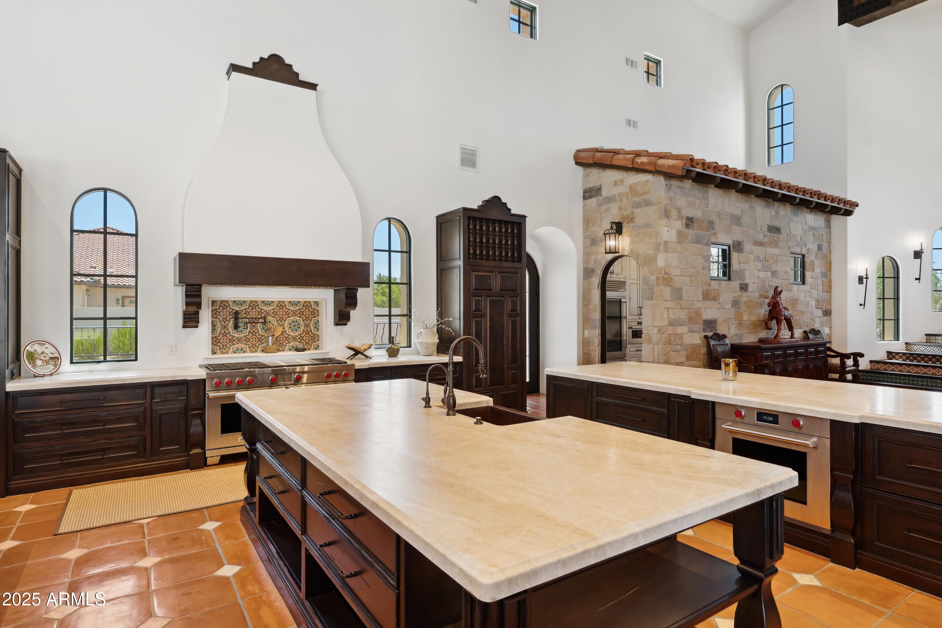 21868 East Stacey Road Queen Creek, AZ 85142 - Photo 18 of 146 a large kitchen with kitchen island a stove a sink a dining table and chairs