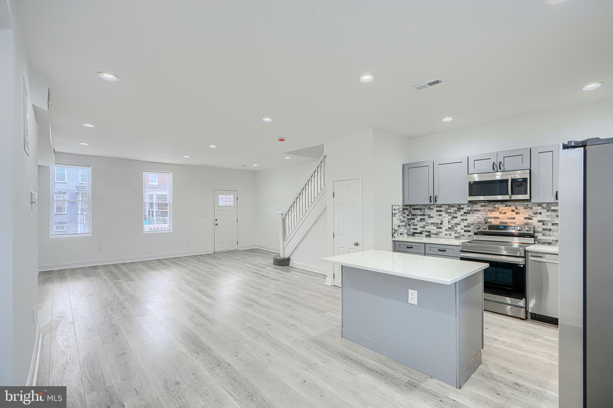 a kitchen with stainless steel appliances kitchen island granite countertop a stove top oven and a sink