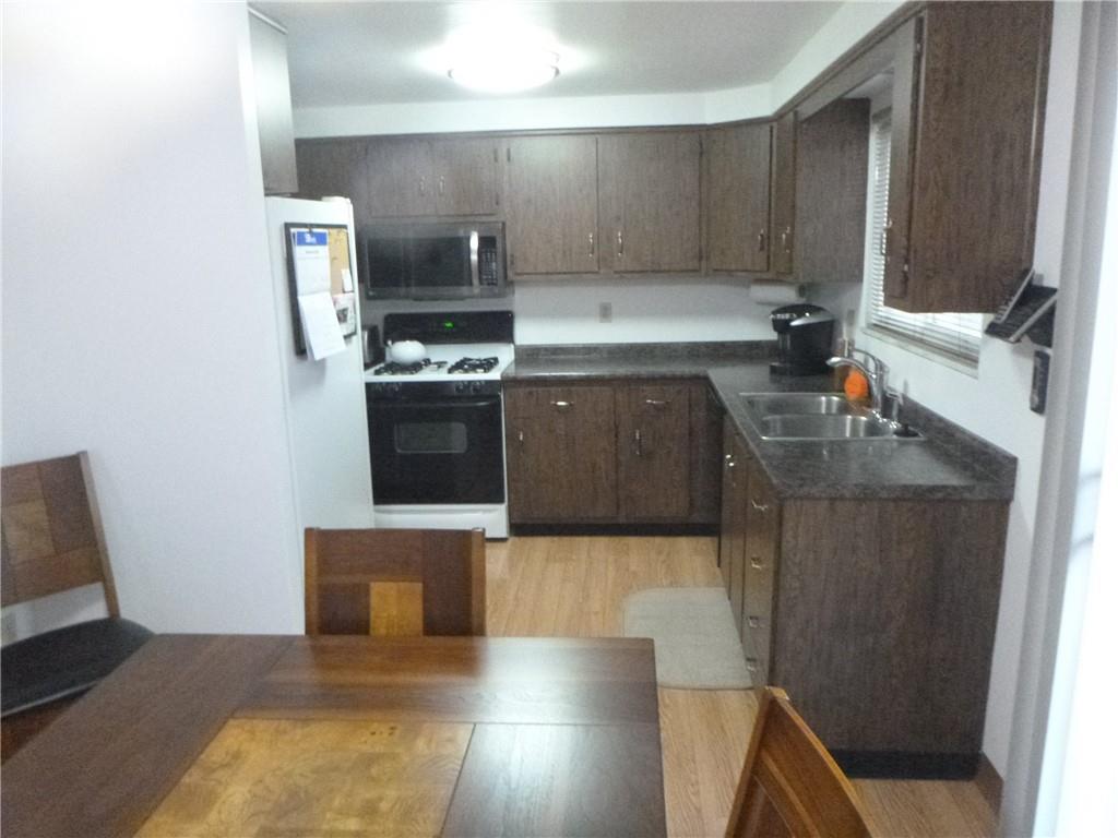 133 Pinto Drive, Unit PINTO DRIVE Plum, PA 15239 - Photo 9 of 21 a kitchen with stainless steel appliances a sink stove and cabinets