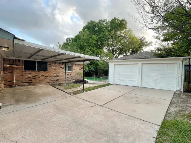 a backyard of a house with basket ball court and garage