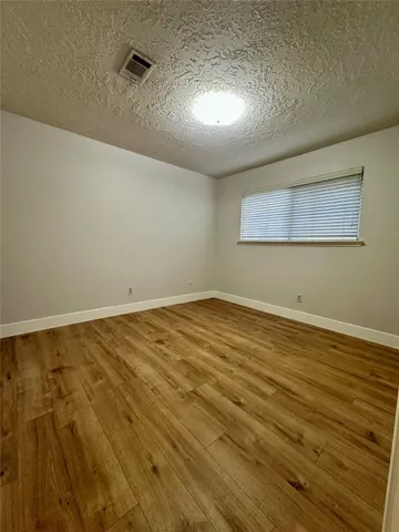a view of a room with wooden floor and white walls