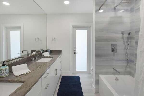 839 Enfield Street Boca Raton, FL 33487 - Photo 13 of 36 a bathroom with a granite countertop sink a mirror a bathtub and shower