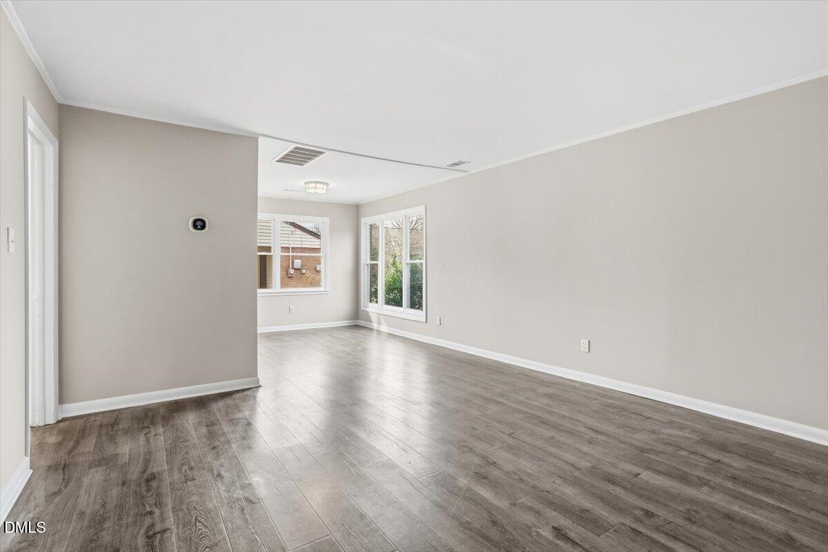 713 Friar Tuck Road Raleigh, NC 27610 - Photo 10 of 29 a view of an empty room with wooden floor and a window