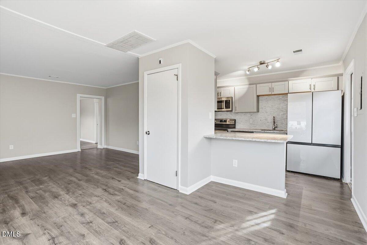 713 Friar Tuck Road Raleigh, NC 27610 - Photo 14 of 29 a kitchen with a refrigerator and white cabinets