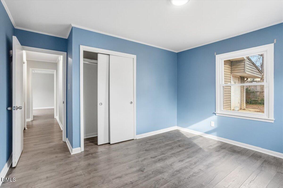 713 Friar Tuck Road Raleigh, NC 27610 - Photo 24 of 29 a view of an empty room with wooden floor and a window