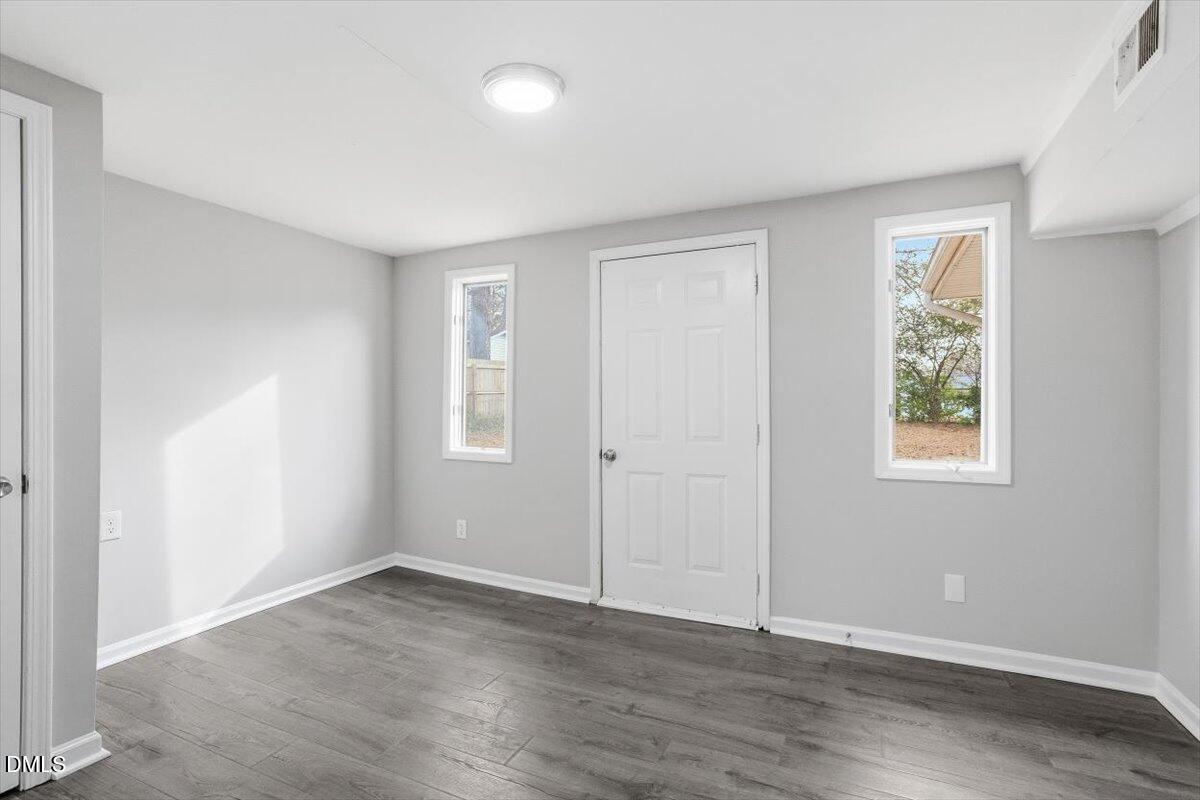 713 Friar Tuck Road Raleigh, NC 27610 - Photo 8 of 29 an empty room with wooden floor and windows