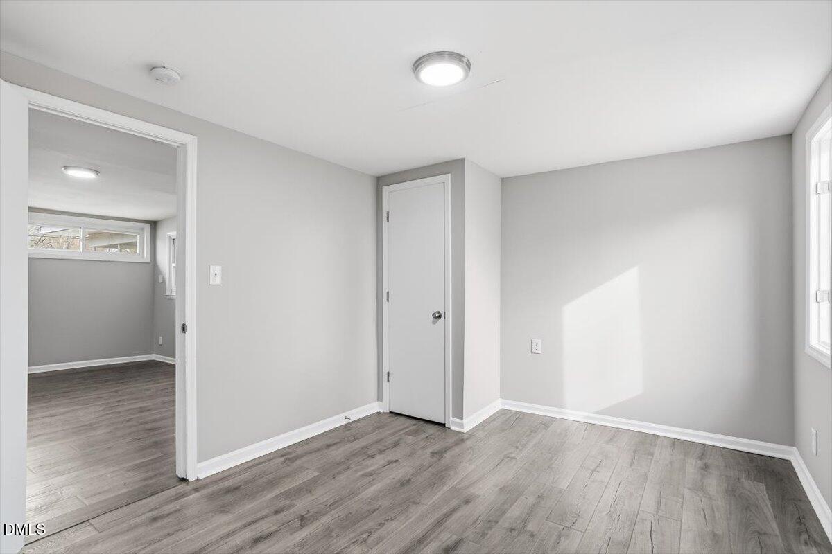 713 Friar Tuck Road Raleigh, NC 27610 - Photo 9 of 29 an empty room with wooden floor & windows