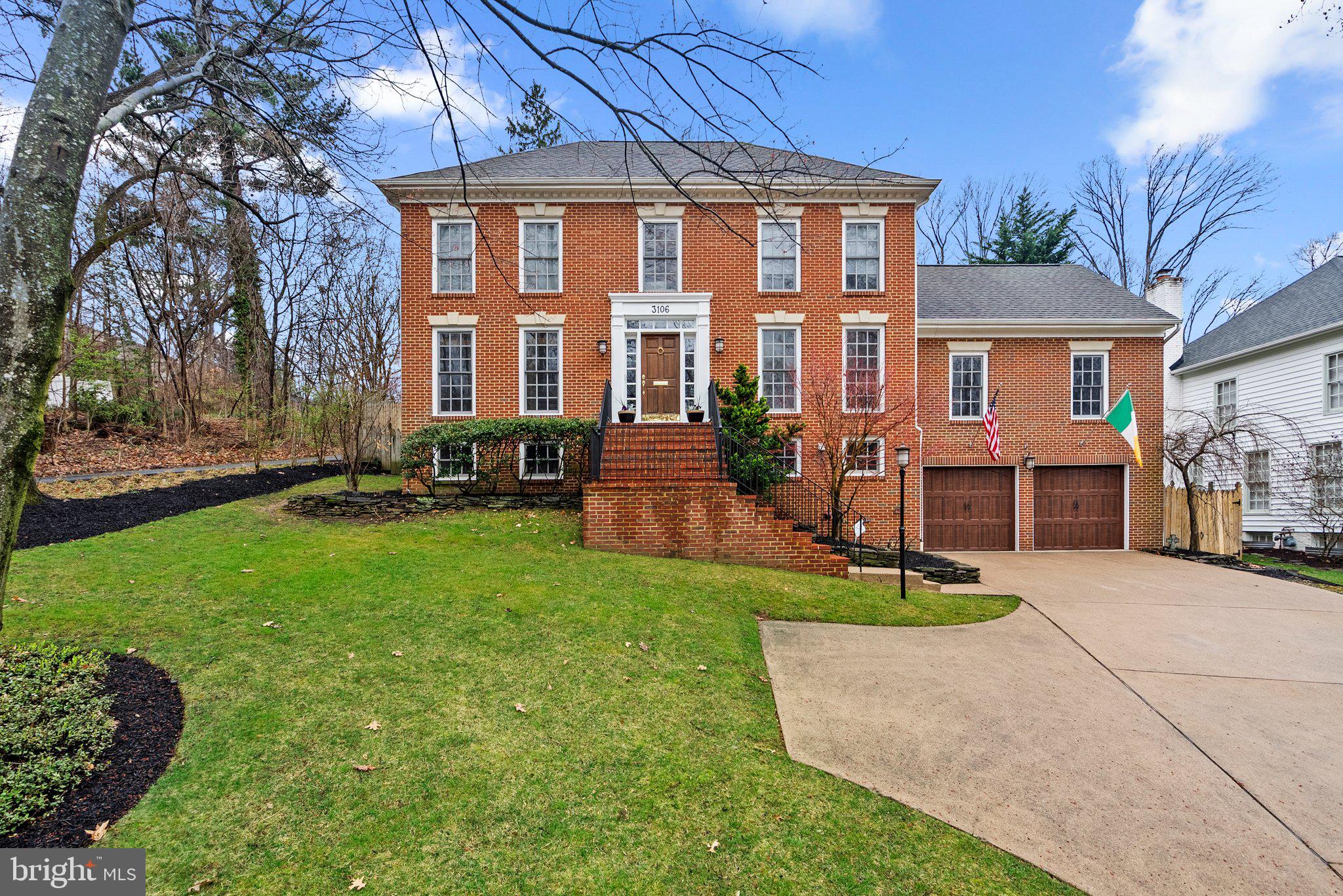 a front view of a house with a yard and trees