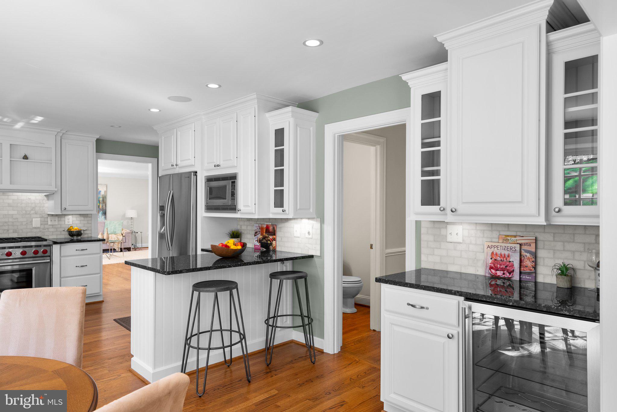 3106 Russell Road Alexandria, VA 22305 - Photo 22 of 62 a kitchen with stainless steel appliances granite countertop a stove top oven a sink a refrigerator and white cabinets with wooden floor