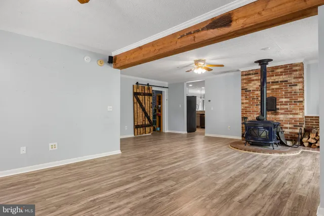 an empty room with wooden floor chandelier fan and closet area