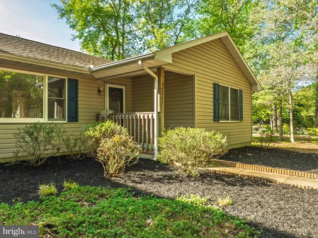 an empty room with wooden floor fireplace and windows