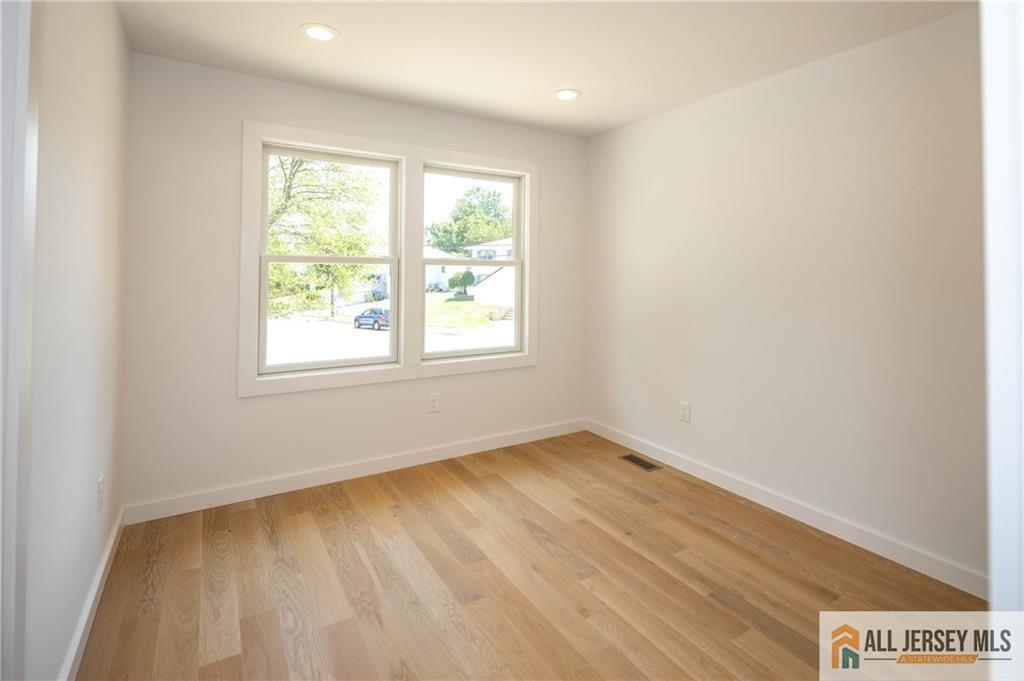 42 Larchmont Road Edison, NJ 08837 - Photo 19 of 36 an empty room with wooden floor and windows