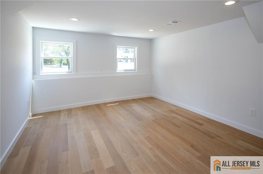 42 Larchmont Road Edison, NJ 08837 - Photo 22 of 36 an empty room with wooden floor and windows