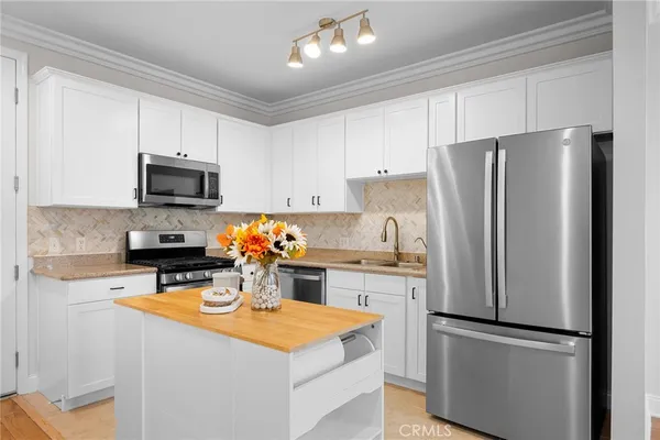 a kitchen with stainless steel appliances granite countertop a refrigerator stove microwave and sink