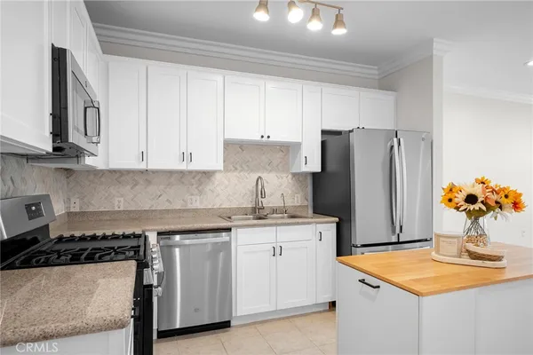 a kitchen with stainless steel appliances granite countertop a refrigerator and a stove