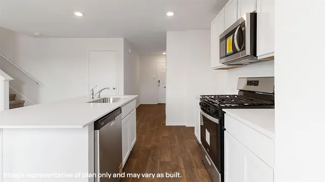 a kitchen with granite countertop a sink and a stove top oven
