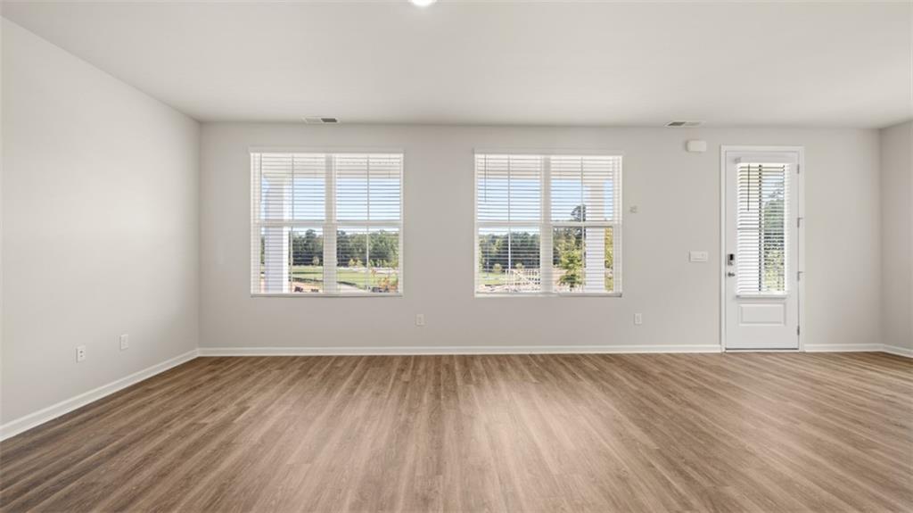918 Stow Lane Sanger, CA 93657 - Photo 16 of 45 an empty room with wooden floor and windows