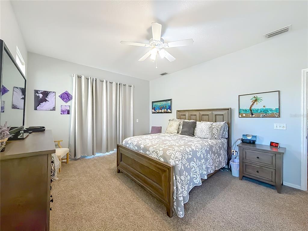 9027 Southwest 196th Court Dunnellon, FL 34432 - Photo 25 of 50 a bedroom with a bed and a chandelier