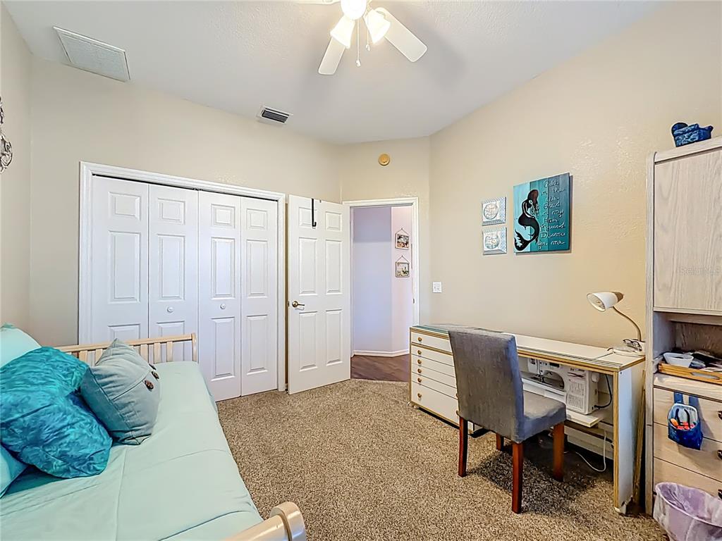 9027 Southwest 196th Court Dunnellon, FL 34432 - Photo 35 of 50 a bedroom with a bed a computer on desk and a chair