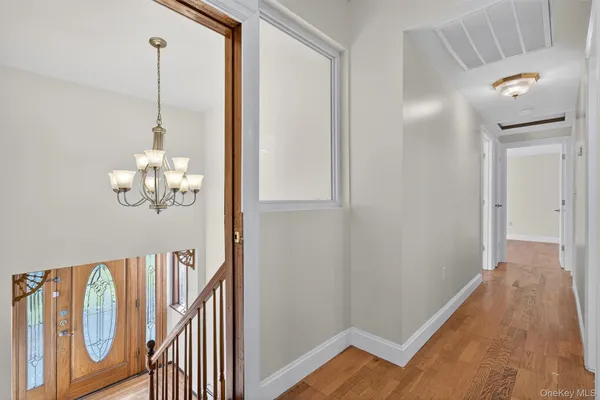 a view of a hallway with wooden floor and staircase
