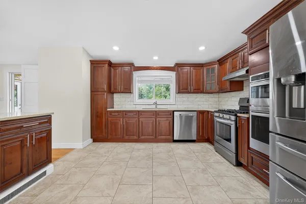 a kitchen with stainless steel appliances granite countertop a stove sink and cabinets