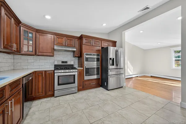 a kitchen with stainless steel appliances granite countertop a refrigerator and a stove top oven