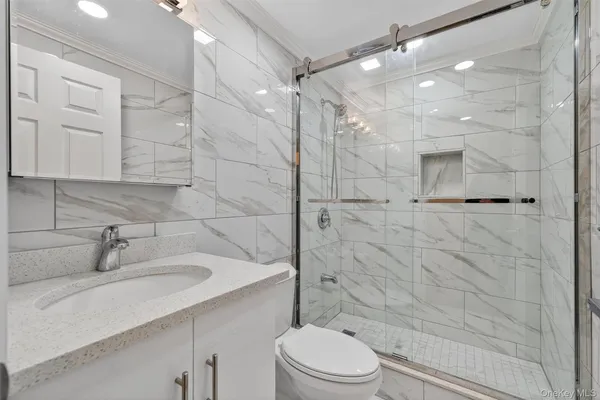 a bathroom with a sink a toilet and shower