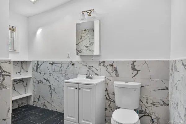 a bathroom with a toilet sink and mirror