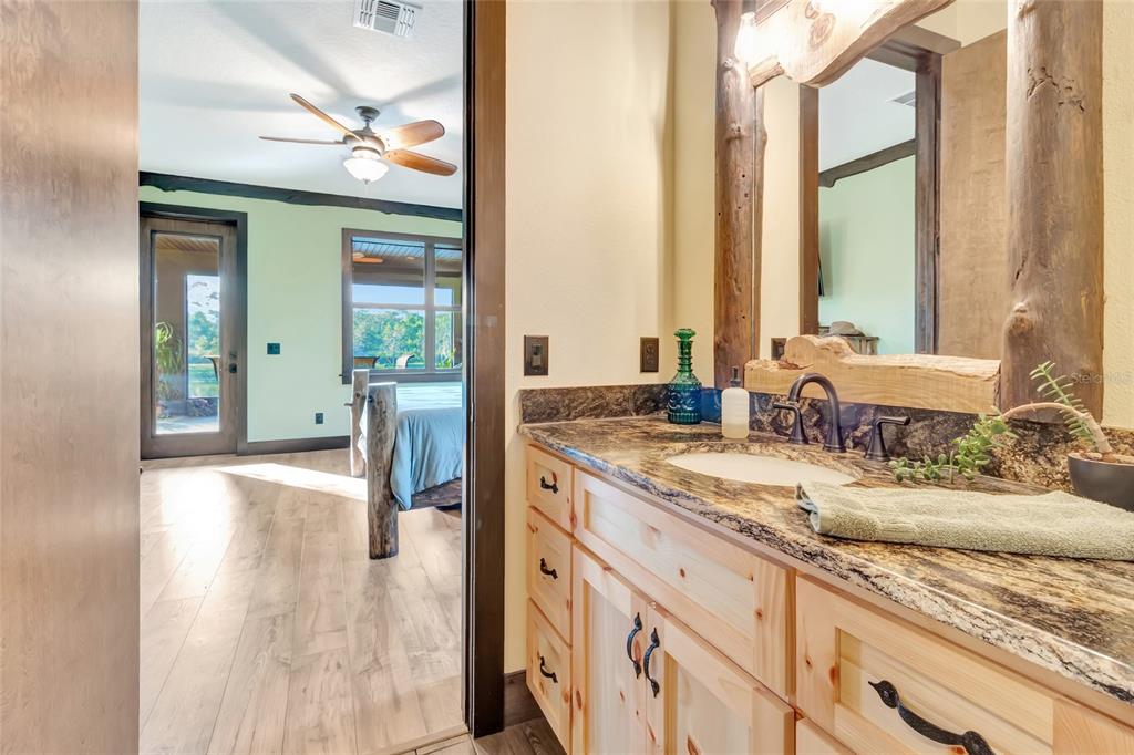 7330 Crabgrass Road St. Cloud, FL 34773 - Photo 26 of 60 a spacious bathroom with a granite countertop sink and a large mirror