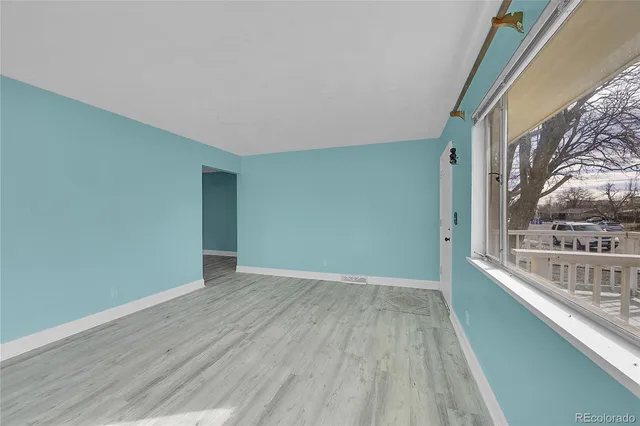 a view of a room with wooden floor and a window
