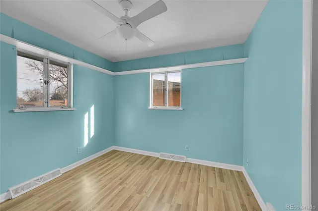 an empty room with a window and wooden floor
