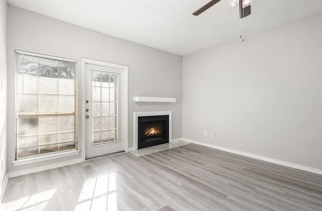 wooden floor fireplace and windows in an empty room