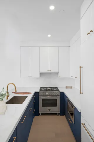 a room with stainless steel appliances kitchen island granite countertop furniture and a potted plant