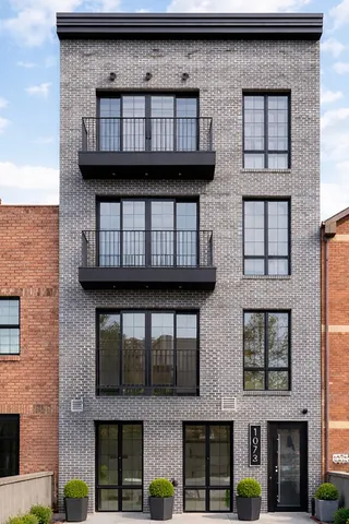a roof deck with couches and potted plants