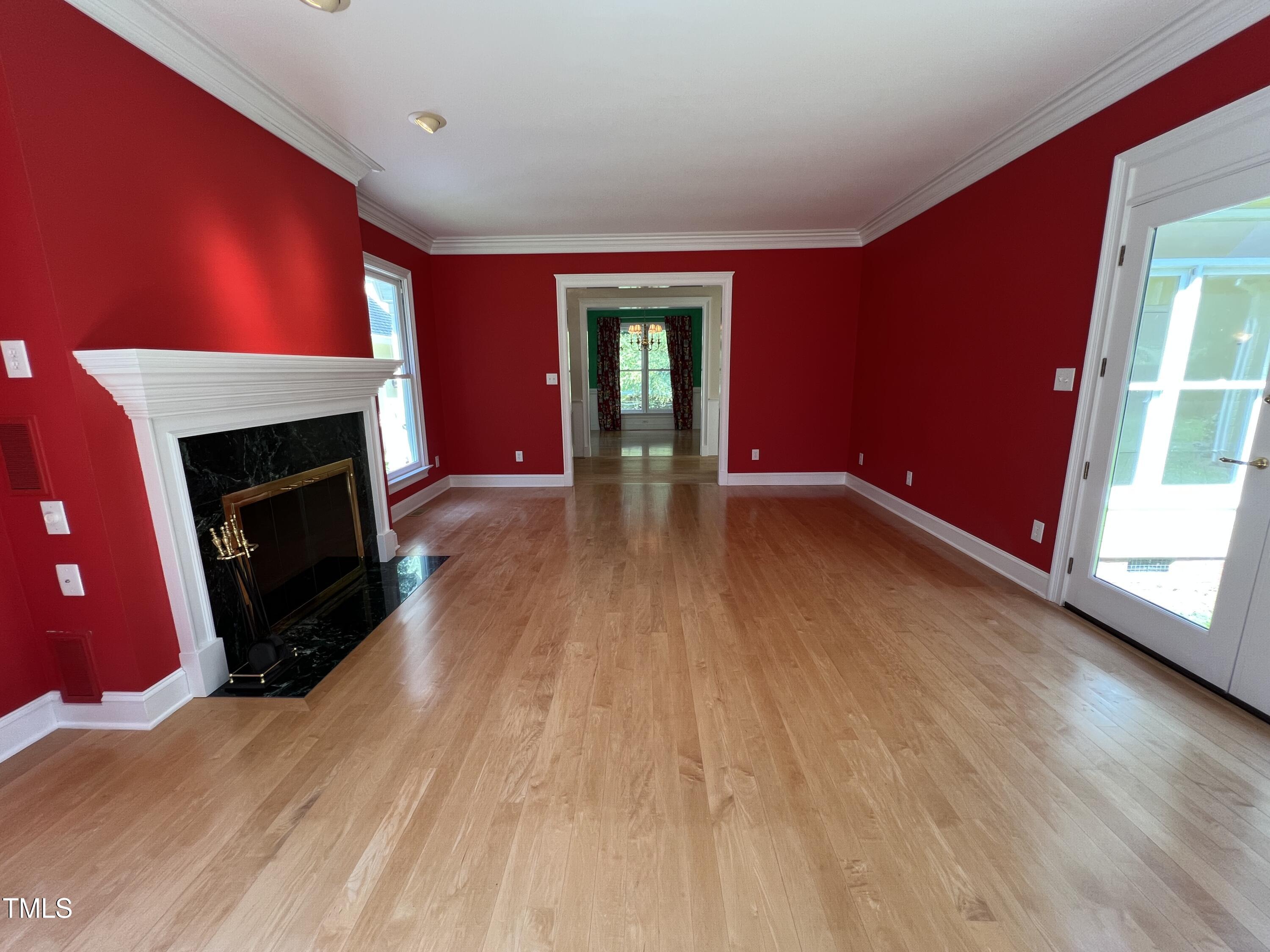 1208 Goodwin Road Apex, NC 27523 - Photo 14 of 42 a view of an empty room with wooden floor fireplace and a window