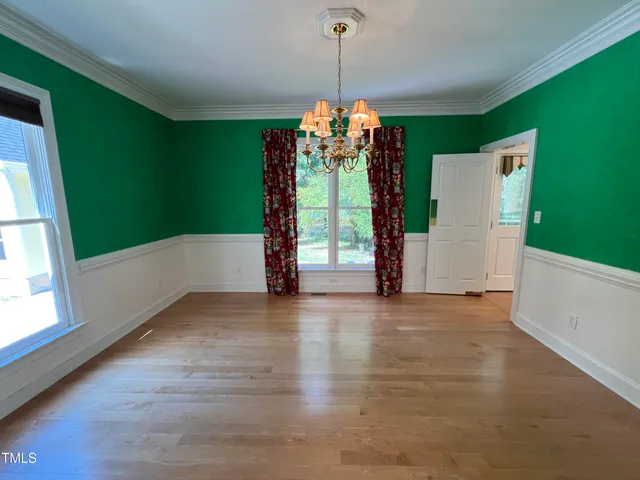 a view of a room with window wooden floor and front door