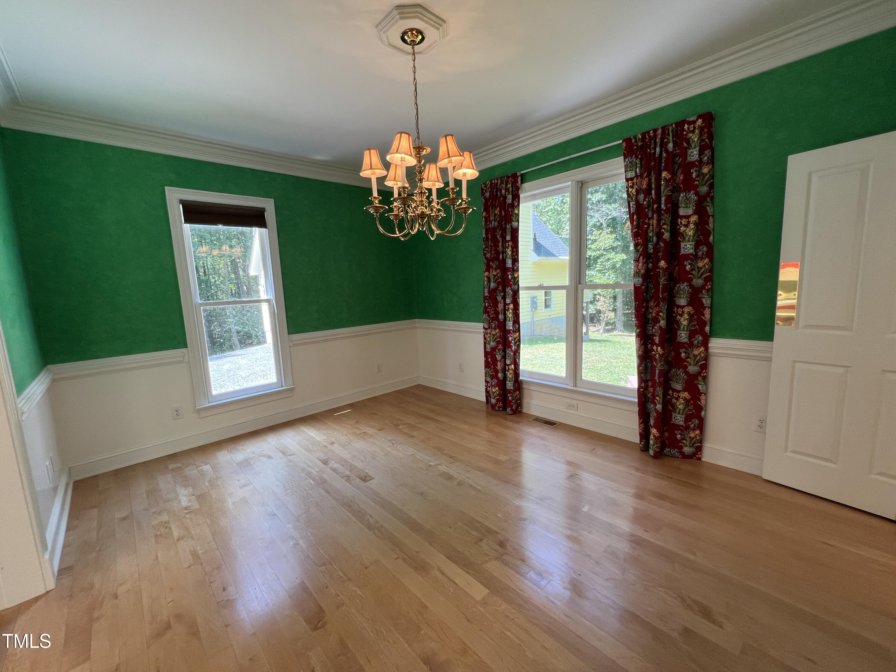1208 Goodwin Road Apex, NC 27523 - Photo 17 of 42 a view of an empty room with wooden floor and a window