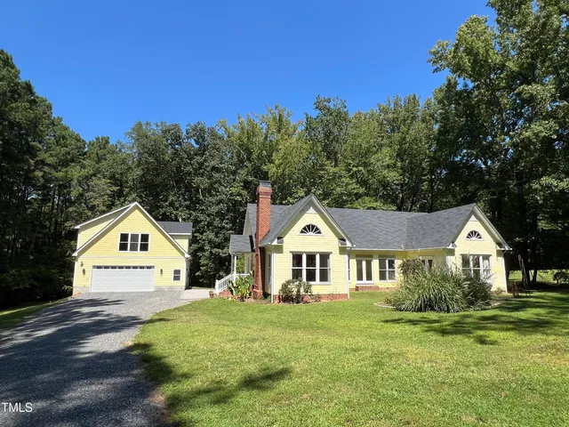 a view of house with garden and trees in the background