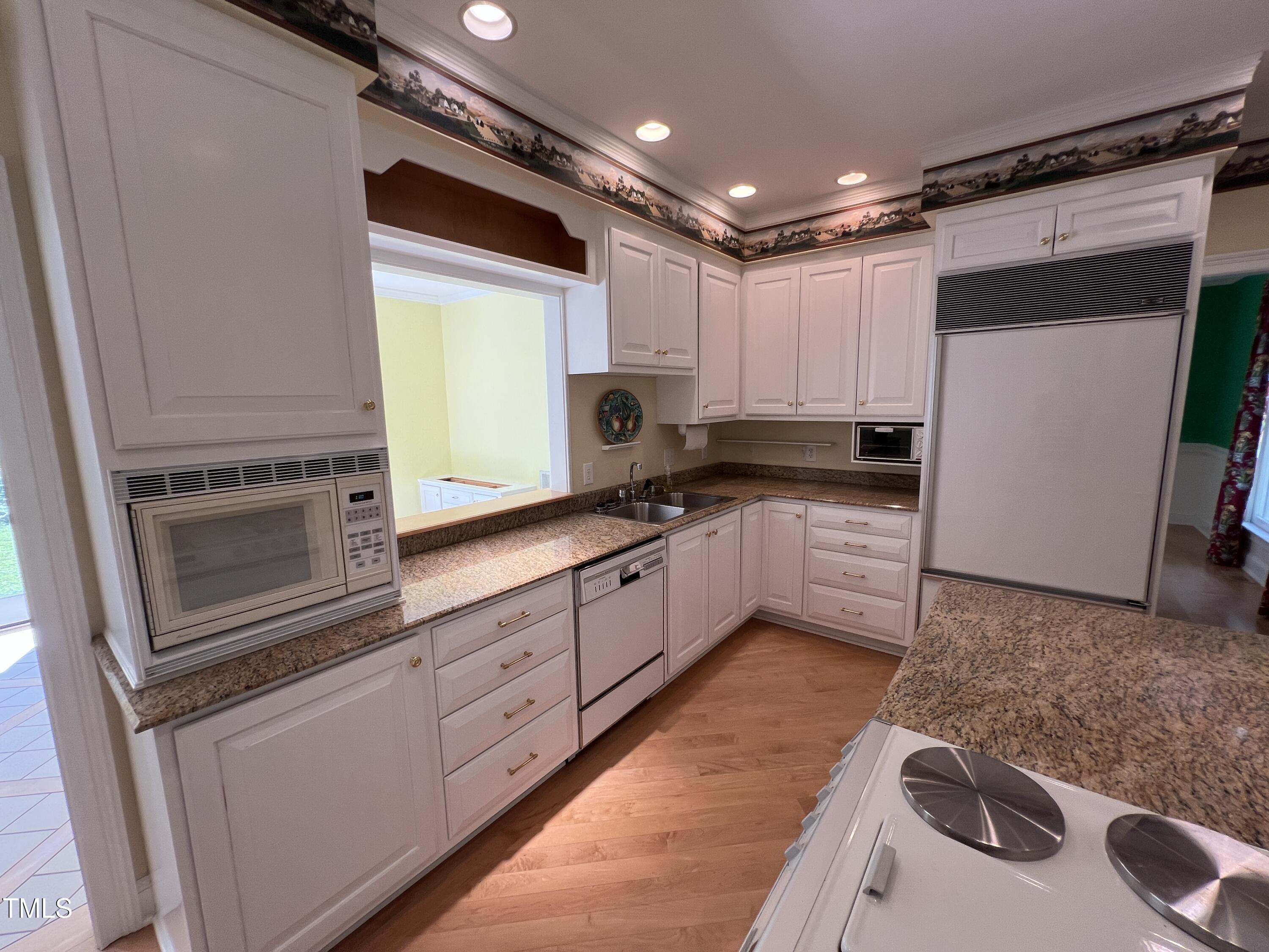 1208 Goodwin Road Apex, NC 27523 - Photo 21 of 42 a kitchen with granite countertop a sink stainless steel appliances a counter top space and cabinets