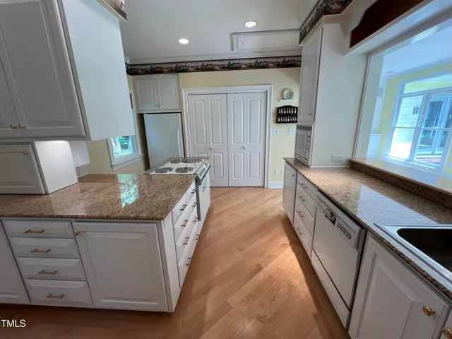 a kitchen with stainless steel appliances granite countertop a sink and a refrigerator