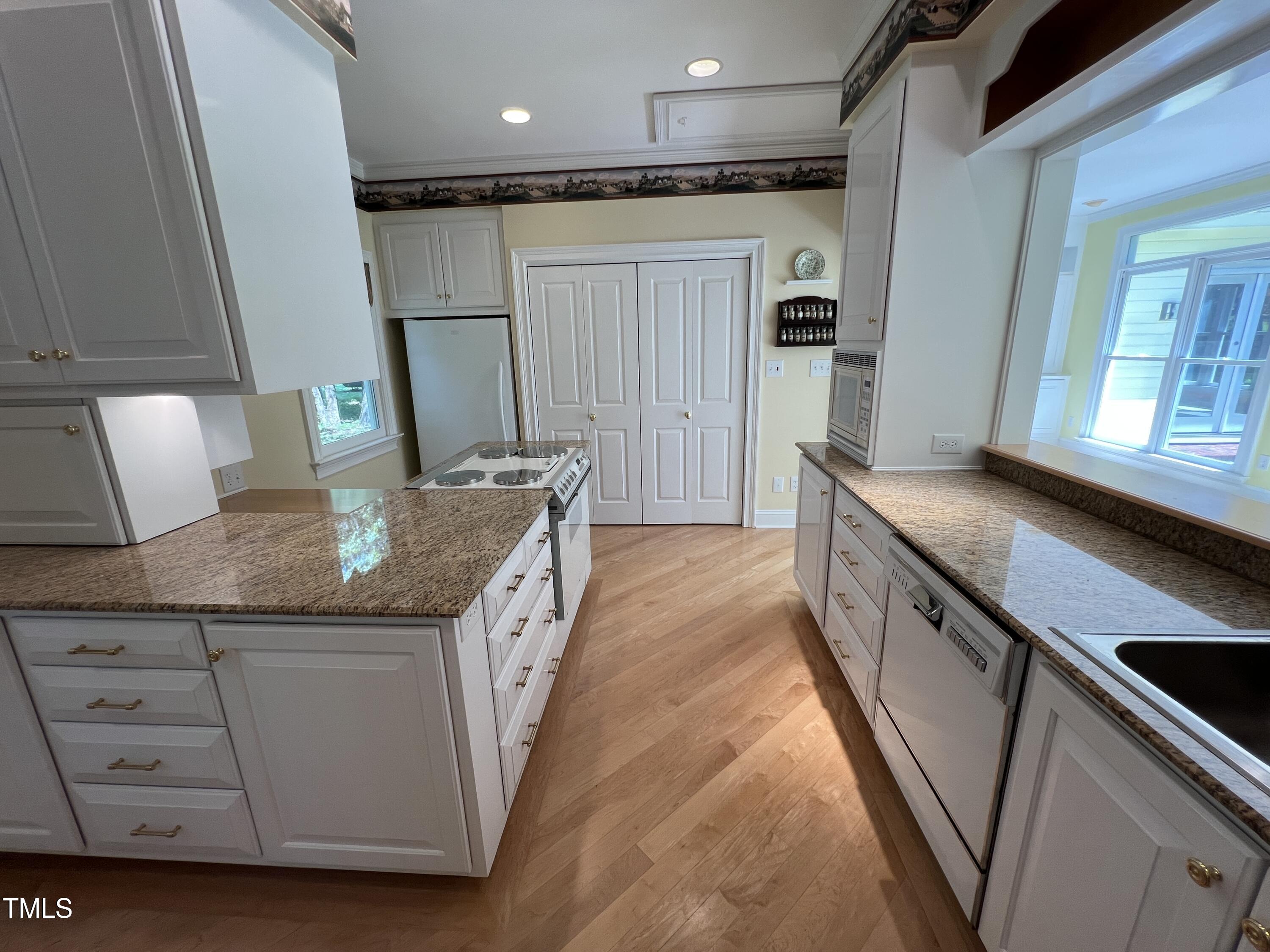 1208 Goodwin Road Apex, NC 27523 - Photo 22 of 42 a kitchen with stainless steel appliances granite countertop a sink and a refrigerator