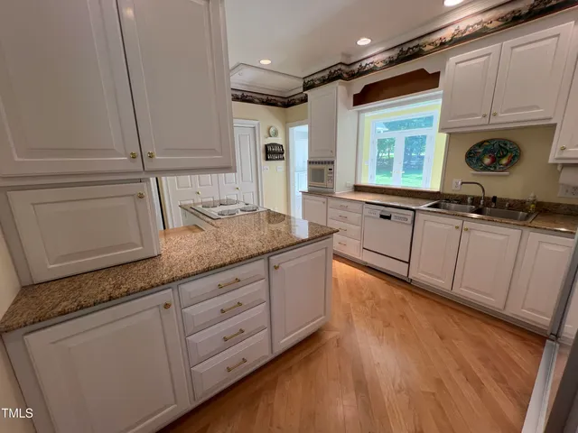 a kitchen with granite countertop white cabinets and white appliances