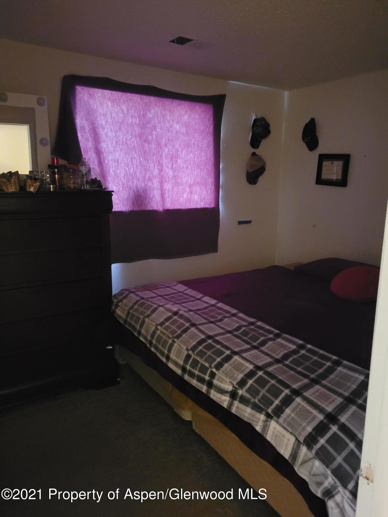 710 East 3rd Street Rifle, CO 81650 - Photo 6 of 9 a bed sitting in a pink room next to a window