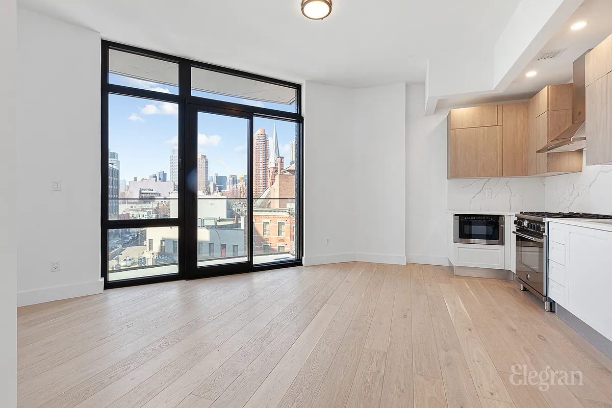 10-64 Jackson Avenue, Unit 4B Queens, NY 11101 - Photo 2 of 10 a view of an empty room with a window and wooden floor