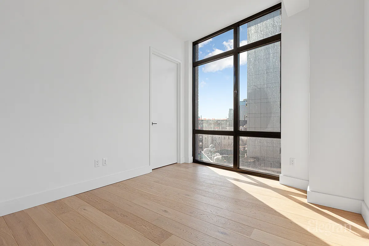 10-64 Jackson Avenue, Unit 4B Queens, NY 11101 - Photo 5 of 10 wooden floor in an empty room with a window