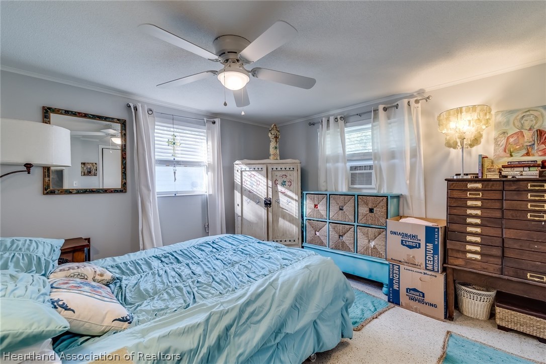 3264 Golfview Road Sebring, FL 33875 - Photo 12 of 27 a bedroom with a large bed and a chandelier